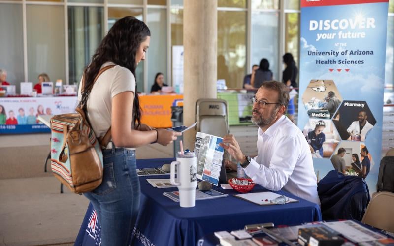 Student speaking to a University of Arizona representative at the 2023 Yuma Transfer and Career Expo hosted by AWC.