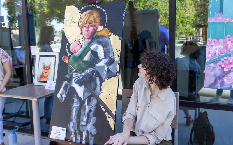 An AWC Student presents a painting at the 2024 AWC Student Showcase