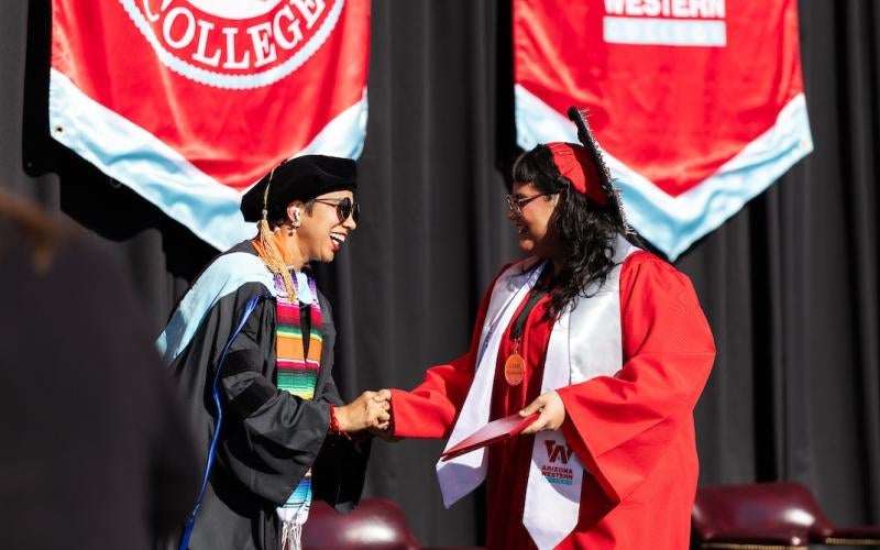 AWC President Dr. Reetika Dhawan congratulates a graduate of the College Assistance Migrant Program (CAMP) at the 2025 Fall Commencement.