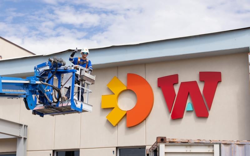 Onvida Health logo and AWC logo next to each other on the outside of the in-construction Health Careers Center. A worker on a lift gives a thumbs up.