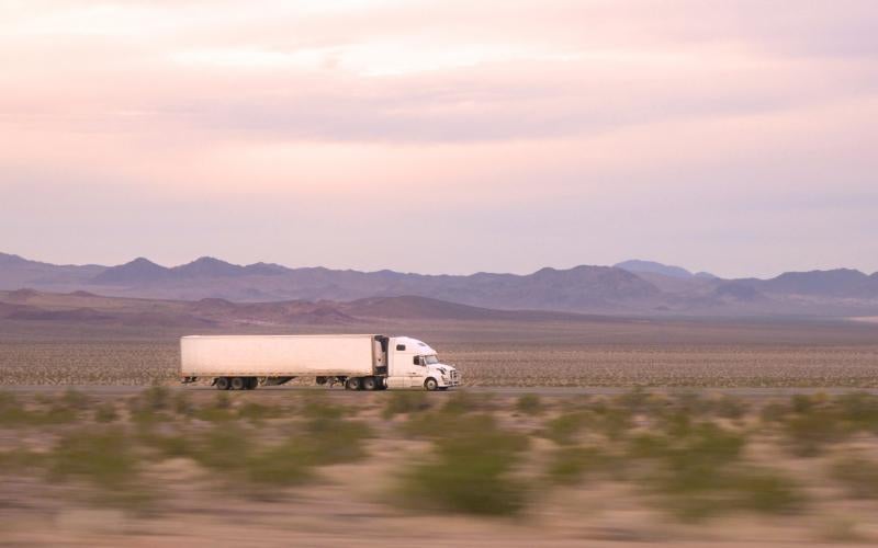 Semi-truck driving down desert highway