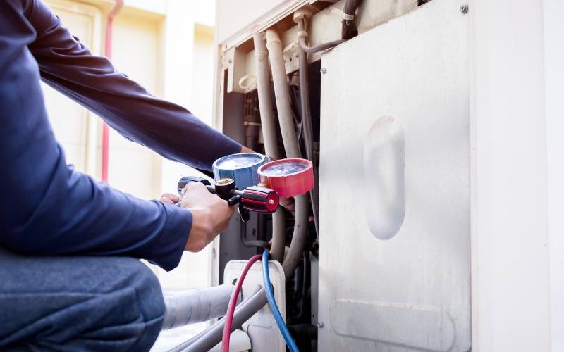 HVAC worker checks an air conditioning unit