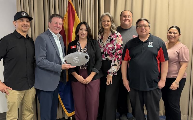 Dr. Daniel Corr stands with the AWC Marketing & Communications team at the AWC District Governing Board meeting on March 26, 2026, holding the National Pacesetter of the Year Award.