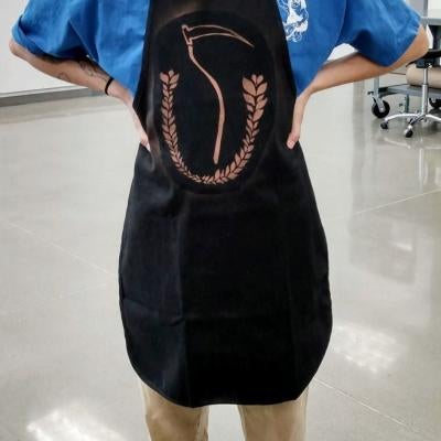 printmaking pieces of a scythe on an apron
