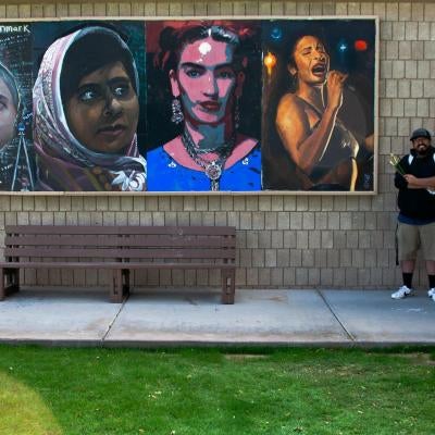 Photo of student by mural