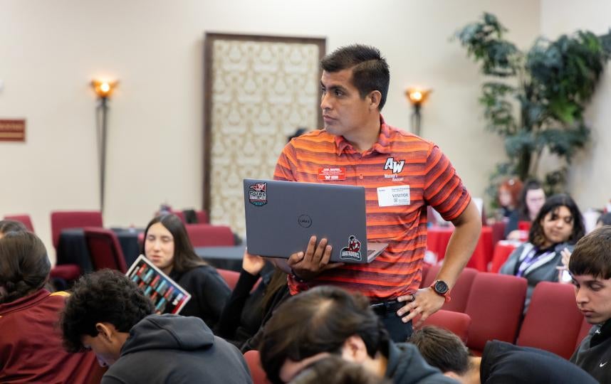 An AWC staff member holding a laptop