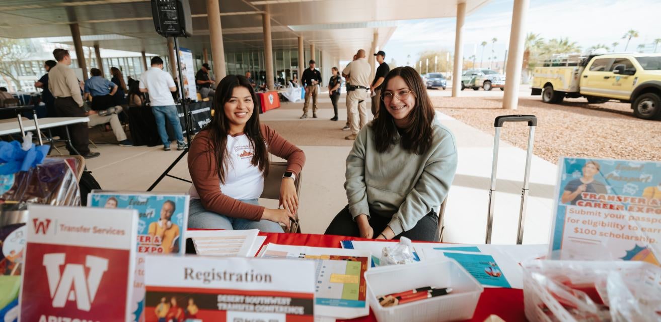 Two people working at Transfer booth at an event